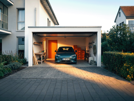 Auto in einer offenen Garage eines Einfamilienhauses