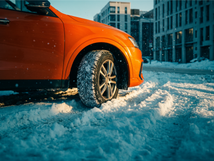 Auto mit Winterreifen auf verschneiter Straße