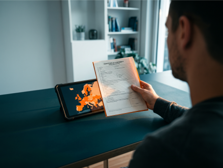 Mann vergleicht Fahrzeugdokumente mit Informationen auf einem Tablet