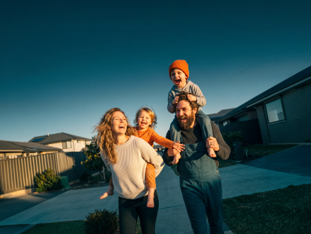 Familie mit Kindern bei einem gemeinsamen Spaziergang im Wohngebiet