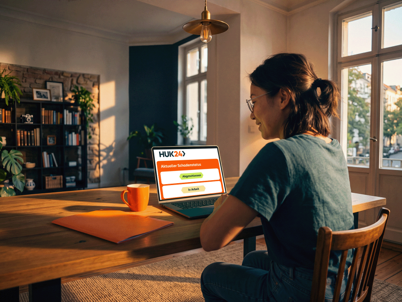 Frau bearbeitet Versicherungsunterlagen an einem Laptop zu Hause