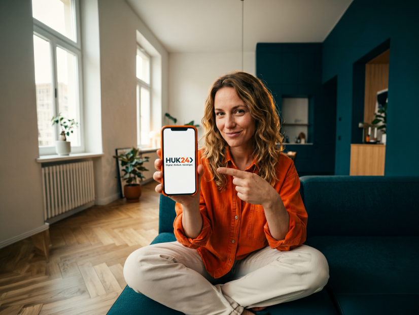 Kundin zeigt das HUK24 Logo auf ihrem Smartphone