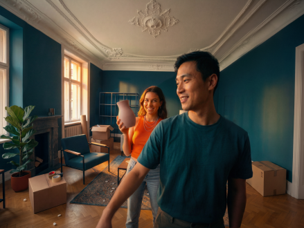 Paar steht zwischen Umzugskartons in seiner neuen Wohnung