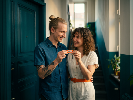 Paar freut sich gemeinsam über den Schlüssel zur neuen Wohnung