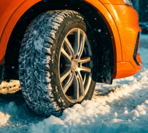 Auto mit Winterreifen auf verschneiter Straße
