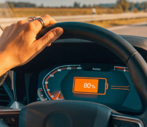 Fahrerin prüft den Akkustand eines Elektroautos während der Fahrt