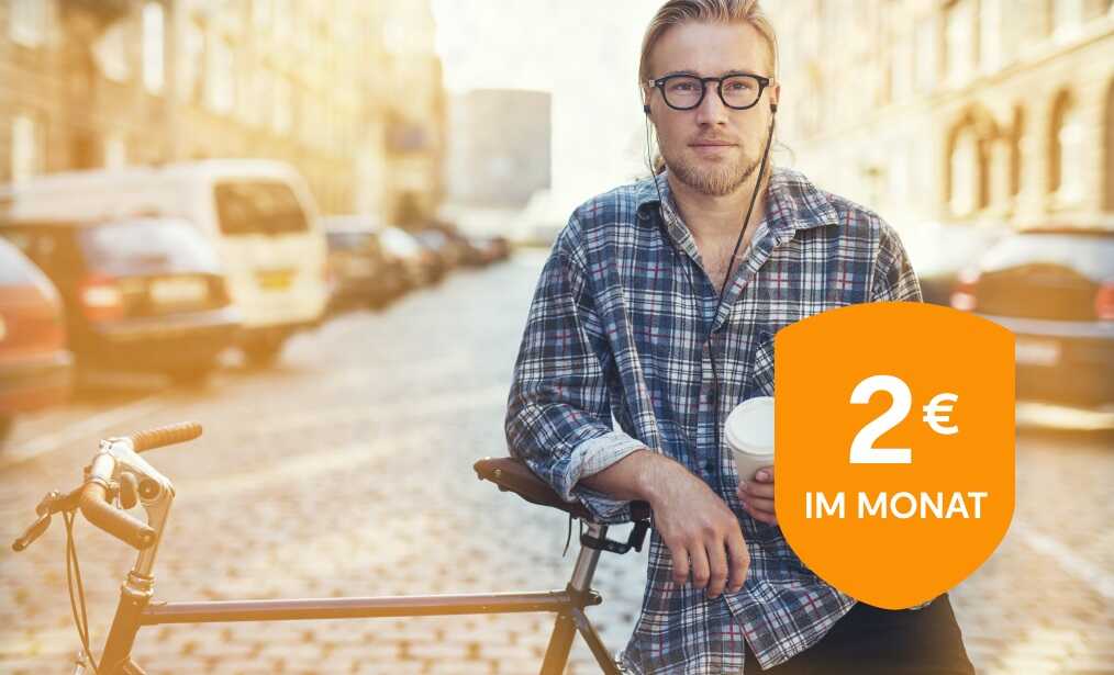 Ein junger Mann mit Kopfhörern im Ohr lehnt auf seinem Fahrrad. 